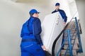 Movers Carrying Refrigerator On Steps At Home Royalty Free Stock Photo