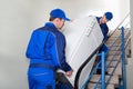 Movers Carrying Refrigerator On Steps Royalty Free Stock Photo