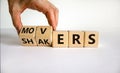 Movers and Shakers symbol. Businessman hand turns cubes and changes the word `shakers` to `movers`. Beautiful white background