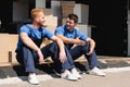 Movers talking while sitting in warehouse Royalty Free Stock Photo