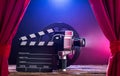 Movie Camera With Clapperboard And Film Reel On Stage Royalty Free Stock Photo