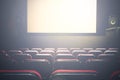 Movie Cinema hall with a white empty screen premiere with red seats Royalty Free Stock Photo
