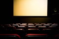 Movie Cinema hall with a white empty screen premiere with red seats Royalty Free Stock Photo