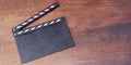 Movie clapper, blank empty clapperboard on wooden background, copy space, overhead. 3d render