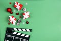 Movie clapper board with Christmas decorations and gifts on a green background with copy space Royalty Free Stock Photo