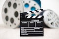 Movie clapper board closeup with movie reels in background Royalty Free Stock Photo