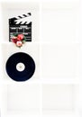 Movie clapper board, film reel and christmas decoration on vertical white bookshelf Royalty Free Stock Photo