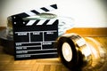 Movie clapper board and 35 mm film reel on wooden floor Royalty Free Stock Photo