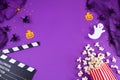 Movie Clapper board in spider webs, spiders, ghost, eyes on purple Lilac Background.