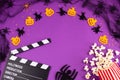 Movie Clapper board in spider webs, spiders, ghost, eyes on purple Lilac Background.