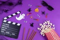 Movie Clapper board in spider webs, spiders, ghost, eyes on purple Lilac Background.