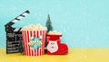 Movie clapperboard with popcorn,christmas ornament,snowflakes and space for text. Christmas movies concept