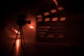 Movie concept. Miniature movie set on dark toned background with fog and empty space. Silhouette of vintage camera on tripod Royalty Free Stock Photo