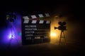 Movie concept. Miniature movie set on dark toned background with fog and empty space. Silhouette of vintage camera on tripod and Royalty Free Stock Photo