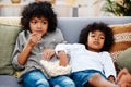 This movie is getting quite interesting. two adorable little boys eating popcorn and watching movies together at home. Royalty Free Stock Photo