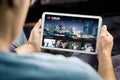 Movie and series stream VOD service in tablet. Watching on demand tv show or film online. Man choosing video entertainment.