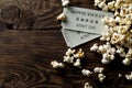 Movie tickets and popcorn on dark wooden table background. Home theatre movie or series night concept. Flat lay top view from