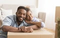 Happy Couple Hugging Sitting Among Unpacked Boxes In New Home Royalty Free Stock Photo