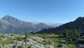 Moving backward above clear blue lake and pine woods in sunny summer day.Europe Italy Alps Valle d`Aosta outdoor green