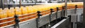 Moving bottles of orange juice on the conveyor belt of a beverage factory.