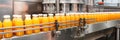 Moving bottles of orange juice on the conveyor belt of a beverage factory. Royalty Free Stock Photo
