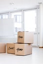 moving boxes in a empty room, home sweet home text in english