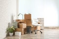 Moving boxes and stuff near white brick wall in room Royalty Free Stock Photo