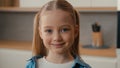 Moving camera close up portrait Caucasian cute little girl at home kitchen smiling looking camera domestic apartment Royalty Free Stock Photo