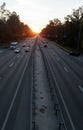 Moving cars on the motorway at sunset time. Highway traffic at sunset with cars. Busy traffic on the freeway, road top view Royalty Free Stock Photo