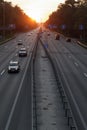 Moving cars on the motorway at sunset time. Highway traffic at sunset with cars. Busy traffic on the freeway, road top view Royalty Free Stock Photo