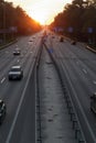 Moving cars on the motorway at sunset time. Highway traffic at sunset with cars. Busy traffic on the freeway, road top view Royalty Free Stock Photo