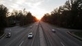 Moving cars on the motorway at sunset time. Highway traffic at sunset with cars. Busy traffic on the freeway, road top view Royalty Free Stock Photo