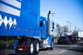 Moving in column blue big rig semi truck and trailer