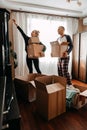 Moving day, new home, unpacking boxes. Happy couple in their new apartment is having fun with cardboard boxes. Cheerful Royalty Free Stock Photo