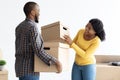 Moving Day. Portrait Of Joyful Young Black Spouses With Cardboard Boxes