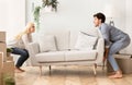 Young Couple Carrying Couch Into New Apartment On Moving Day Royalty Free Stock Photo