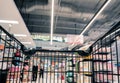 Moving empty black shopping cart with motion in the supermarket aisle, customer choosing product on market shelf store