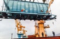 Moving freight railway car in the port by a port crane. Cargo lifting operations. Industrial port