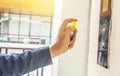 A moving hand of man disinfecting lift push button by spraying blue sanitizer bottle. Protection against infectious virus, Royalty Free Stock Photo