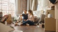 Moving In: Happy Couple Talk, Sitting on a Living Room floor of their New Cozy Home. Cheerful Young Royalty Free Stock Photo