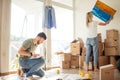 Moving house. Couple hanging picture on wall in new home Royalty Free Stock Photo