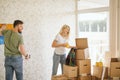 Moving house. Couple hanging picture on wall in new home Royalty Free Stock Photo