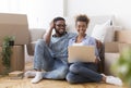 Happy Couple Using Laptop Sitting On Floor In New Home Royalty Free Stock Photo