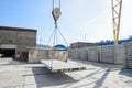 Moving a pdn road slab by a crane across the warehouse of a reinforced concrete plant.