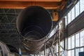 Moving pipes inside the workshop with an overhead crane using a traverse Royalty Free Stock Photo