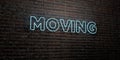 MOVING -Realistic Neon Sign on Brick Wall background - 3D rendered royalty free stock image