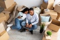 Moving, relocating concept. Loving african american couple purchasing furniture for new apartment, using laptop Royalty Free Stock Photo