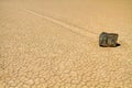 Moving rock on cracked desert ground