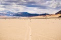 Moving rocks and their tracks at the Racetrack Playa; mountains and clouds scenery in the background; Death Valley National Park, Royalty Free Stock Photo