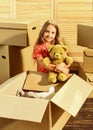 Moving routine. Only true friend. Girl child play with toy near boxes. Packaging things. Move out concept. Stressful